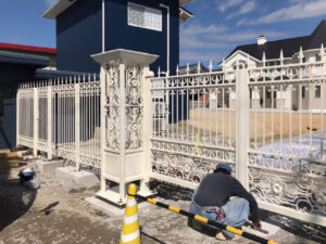 剣先装飾デザインの白塗装ロートアイアン門扉とフェンス施工風景