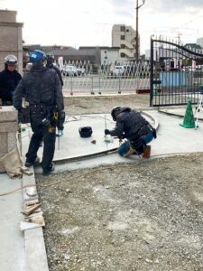 学校施設向けロートアルミ大型引き戸門扉のステンレスレールを本溶接している様子