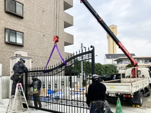 熊本県の学校施設でロートアルミ大型門扉を重機で吊り上げる施工作業