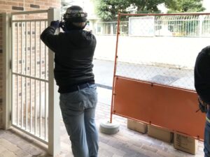 ロートアルミ大型門扉の丁番を取り付けている施工の様子