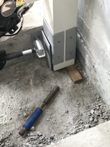 ロートアルミ大型門扉の支柱基礎となるスチール金具を固定している様子