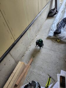 名古屋市千種区でロートアイアン門扉を施工するため足元をレーザーで位置出しを行う様子
